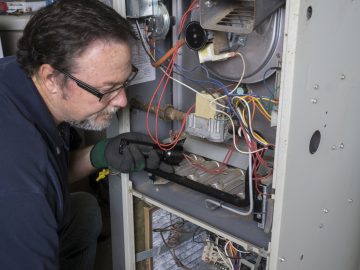 Technician Looking Over A Gas Furnace